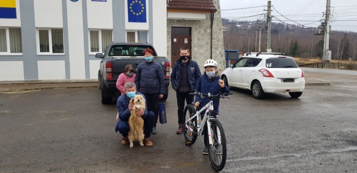 Voluntarii de la CERT i-au dăruit o bicicletă nouă băiatului care a tras cu sania un câine în Râșca