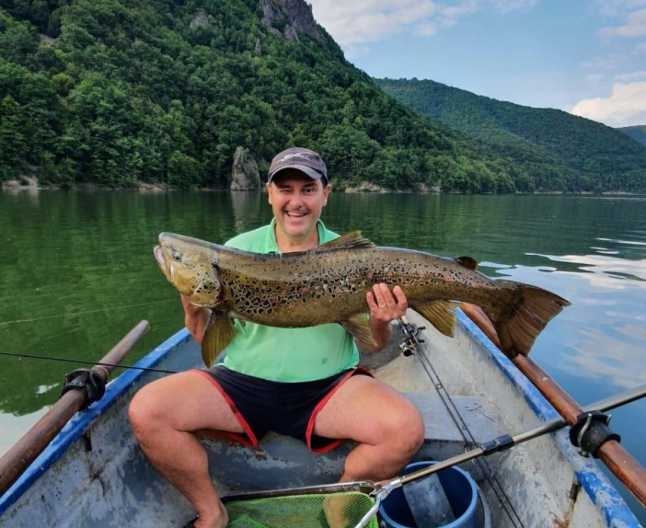 FOTO. Păstrăv curcubeu uriaș, prins de un senator în lacul Tarnița. S-a luptat 4 ore să scoată peștele din apă