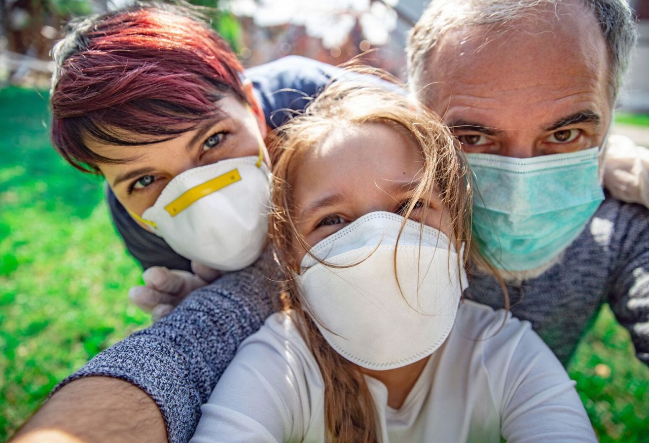 Familie împreună, purtând masca de protecție, în pandemia de COVID