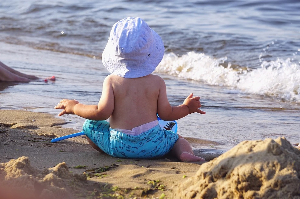 Bebeluș la mare care se joacă în nisip. Foto: Pixabay