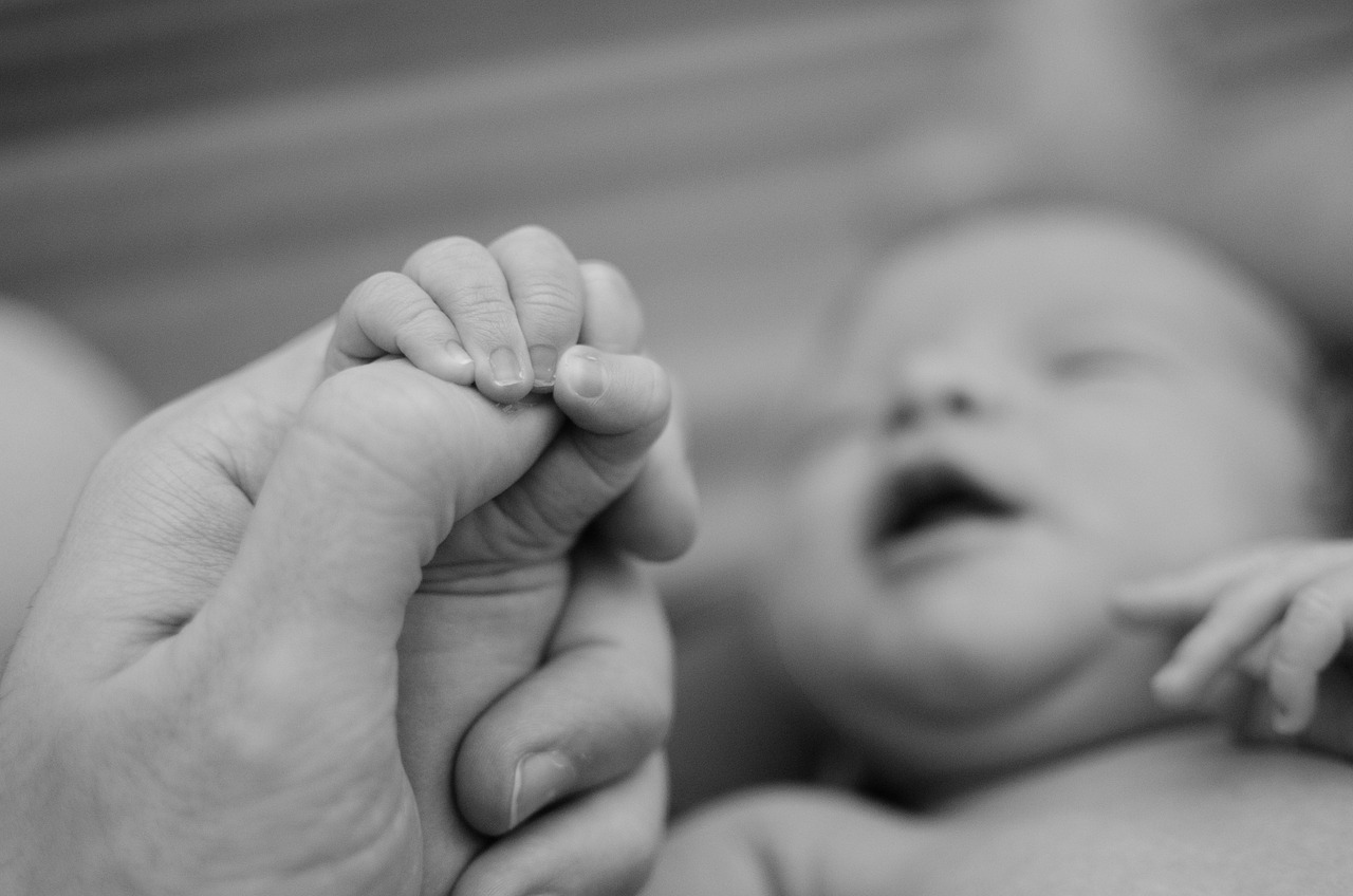 Nou născut ținut de mână de mama lui. Foto: Pixabay