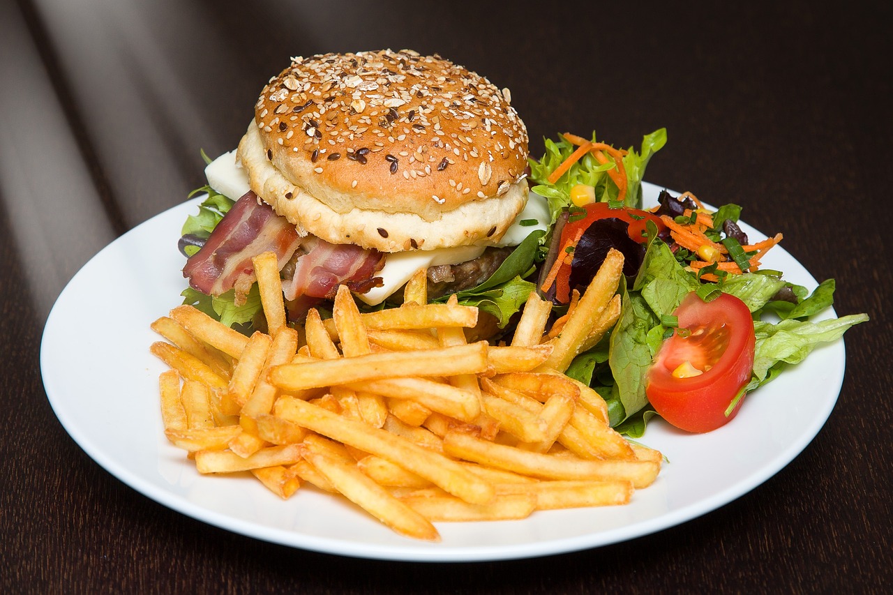 Cartofi prajiți și un burger pe farfurie. Foto: Pixabay