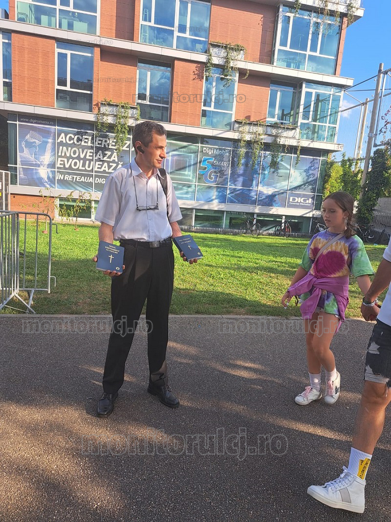 Un pastor neoprotestant îi întâmpină pe tineri cu biblii, duminică, pe 11 august, la intrarea în festivalul Untold. Foto: Bianca Preda | monitorulcj.ro