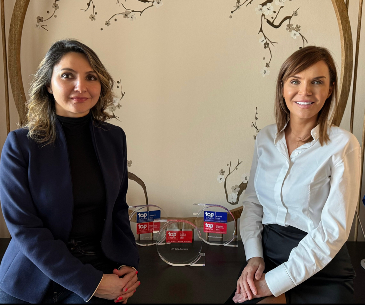 Adela Negru, Chief HRO, și Maria Metz, CEO NTT DATA Romania, prezintă cu mândrie cele trei trofee Top Employer obținute trei ani la rând | Foto: NTT DATA Romania