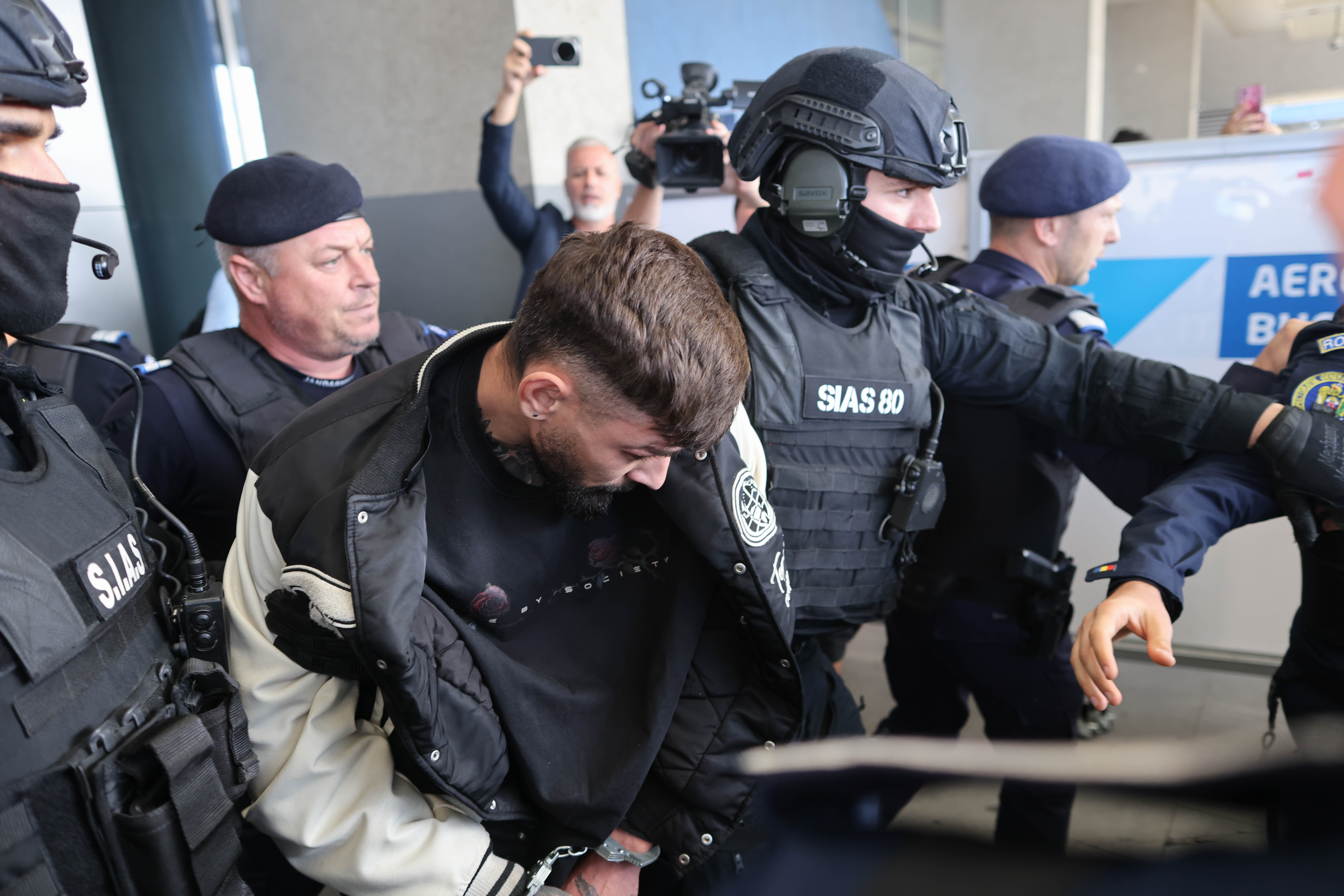 Vlad Baltateanu este escortat de politisti in afara Aeroportului international Henri Coanda din Otopeni, 6 octombrie 2026. Inquam Photos / George Calin
