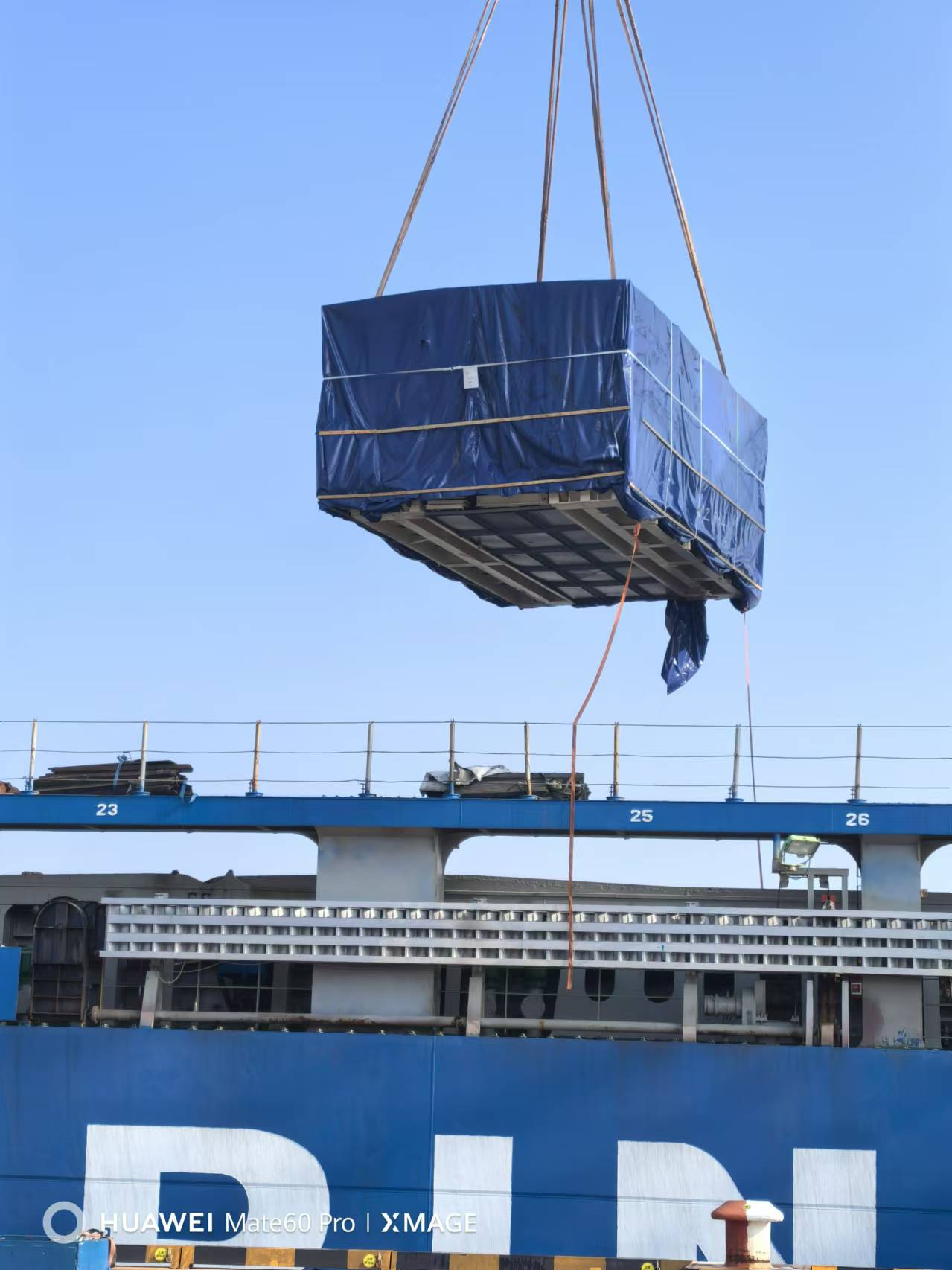 A large container being lifted by a crane

Description automatically generated