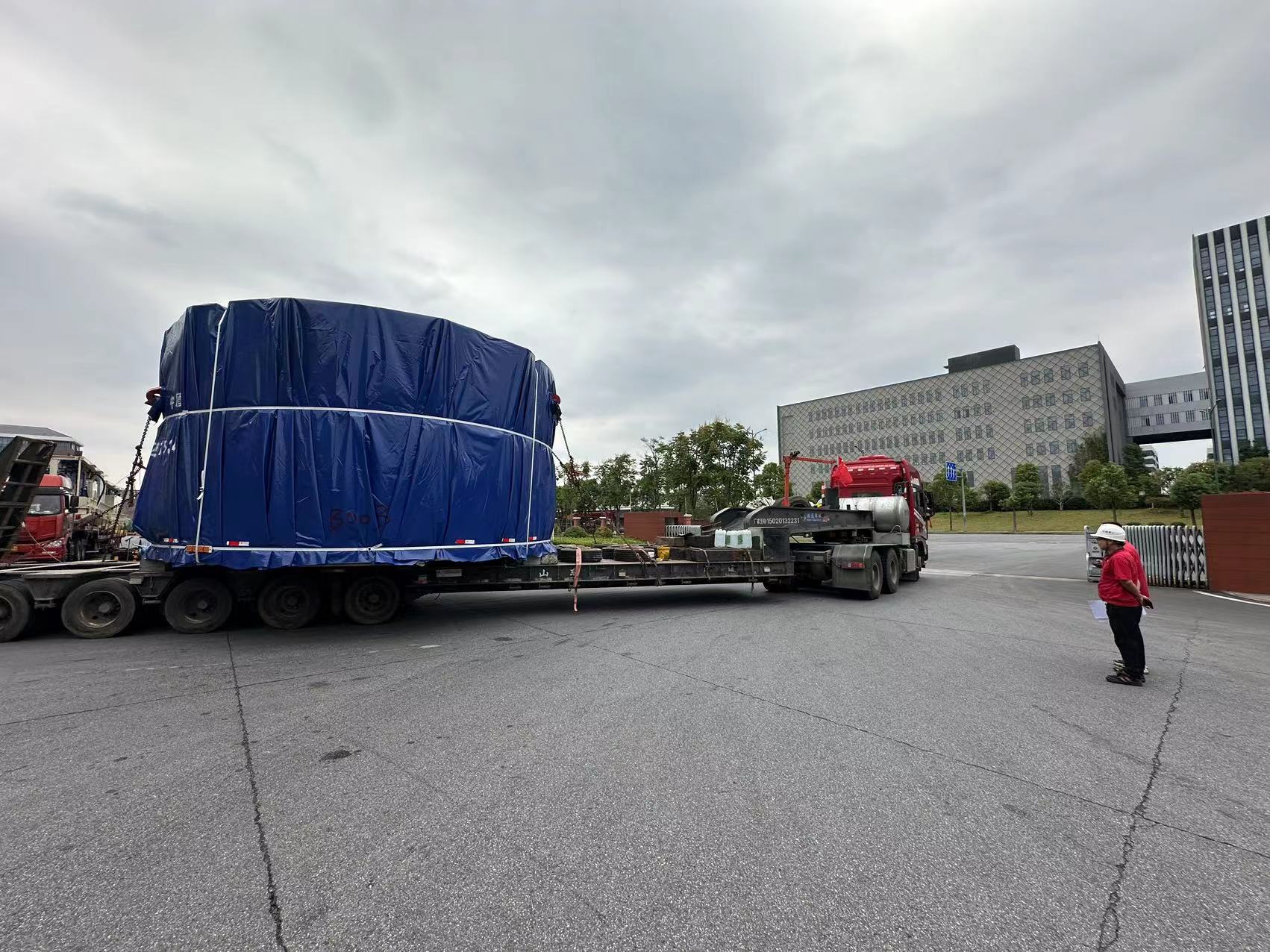 A semi truck with a blue tarp on it

Description automatically generated